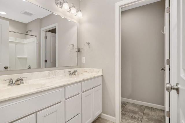 5010 Sandpebble Ln, Woodbury, MN 55129 - bathroom featuring double vanity, baseboards, and a shower