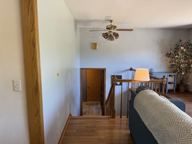 507 Pine Ridge Ter, River Falls, WI 54022 - hall featuring wood finished floors, an upstairs landing, a textured ceiling, and baseboards