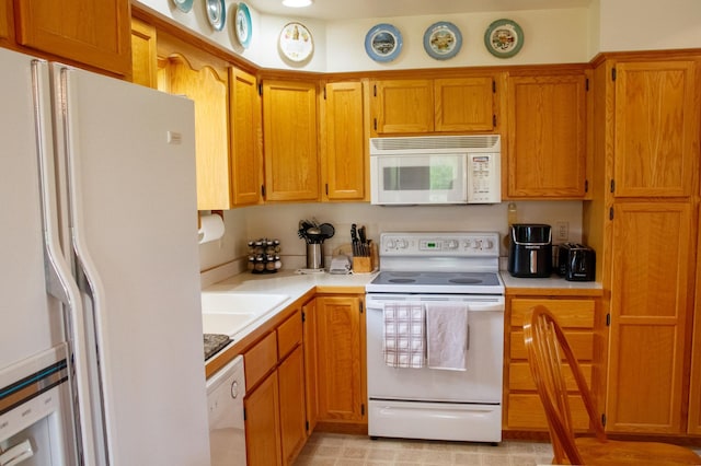 11005 320th St, Clover Twp, MN 56470 - kitchen with white appliances, light countertops, a sink, and brown cabinetry