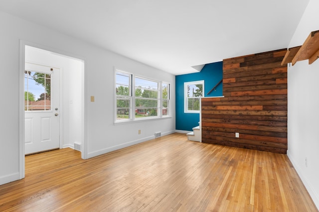 1507 7th Ave NW, Rochester, MN 55901 - unfurnished living room with light wood-style flooring, plenty of natural light, baseboards, and stairway