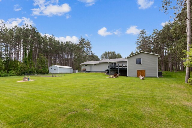 4765 344th Ln NW, Cambridge, MN 55008 - view of grassy yard featuring an outdoor structure, a deck, and central AC