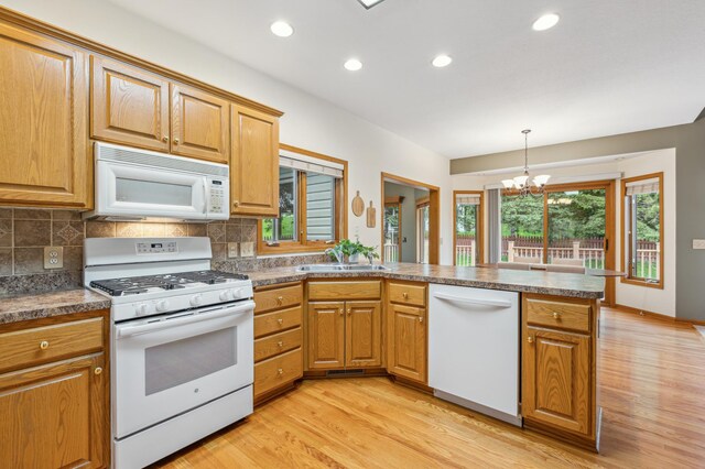 307 Lincoln Dr SE, Saint Michael, MN 55376 - kitchen with white appliances, a peninsula, a sink, a chandelier, and light wood-type flooring