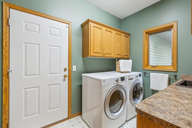 307 Lincoln Dr SE, Saint Michael, MN 55376 - washroom with cabinet space, independent washer and dryer, baseboards, a textured ceiling, and light floors