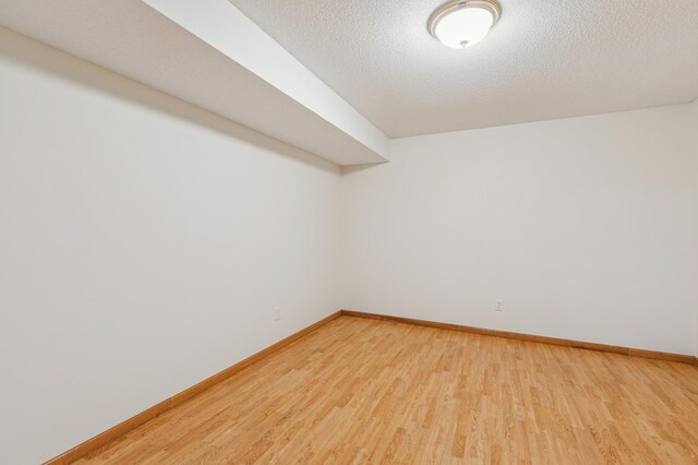 307 Lincoln Dr SE, Saint Michael, MN 55376 - spare room featuring light wood-type flooring, baseboards, and a textured ceiling