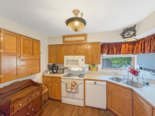 602 26th St, Scanlon, MN 55720 - kitchen featuring white appliances, a sink, light countertops, light wood-type flooring, and brown cabinets