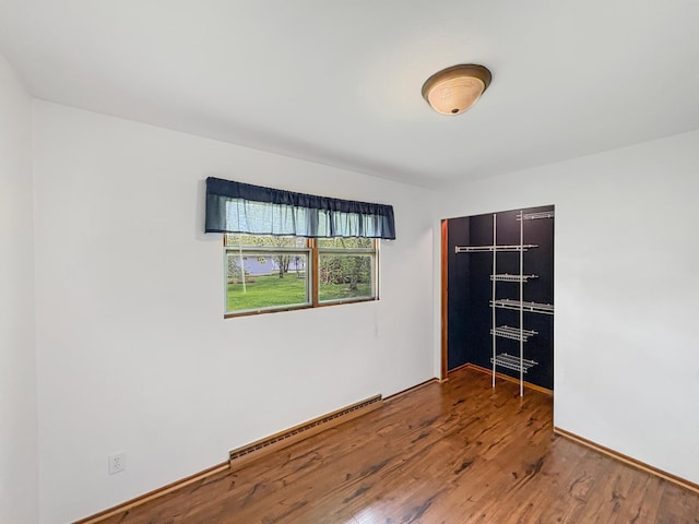 602 26th St, Scanlon, MN 55720 - empty room with baseboard heating and wood finished floors