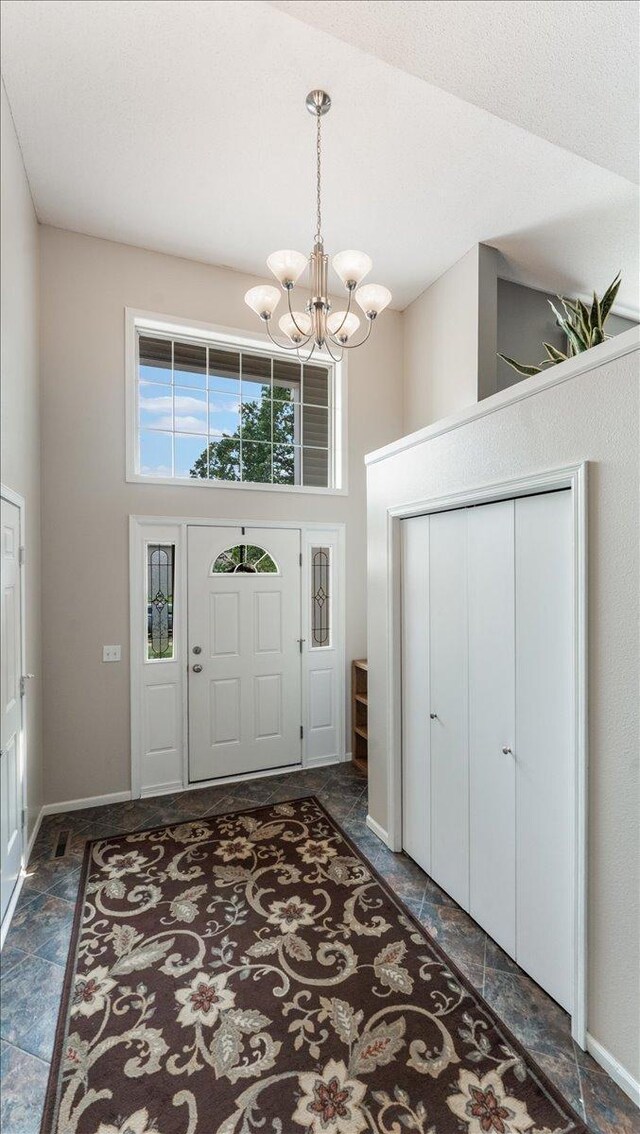 13590 Jesse St, Becker, MN 55308 - entryway with a chandelier, a high ceiling, baseboards, and stone finish flooring