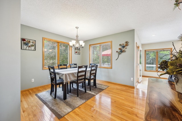 582 139th Ln NW, Andover, MN 55304 - dining space featuring plenty of natural light, a textured ceiling, a chandelier, light wood-type flooring, and baseboards