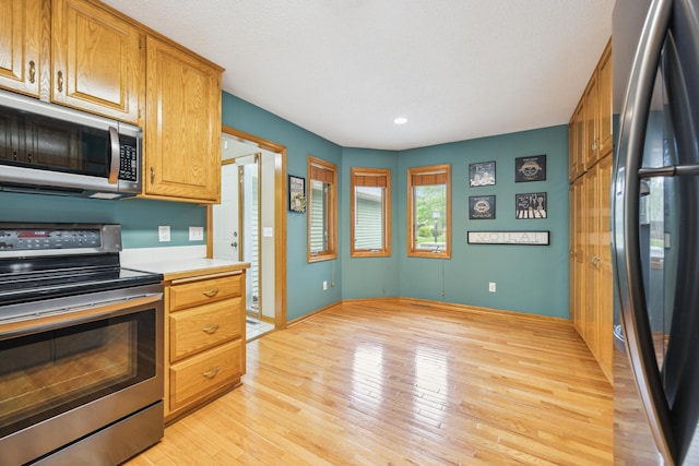 582 139th Ln NW, Andover, MN 55304 - kitchen featuring stainless steel appliances, light countertops, light wood-type flooring, recessed lighting, and brown cabinets