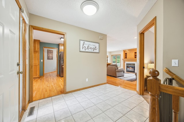 582 139th Ln NW, Andover, MN 55304 - corridor with light tile patterned floors, a textured ceiling, and baseboards