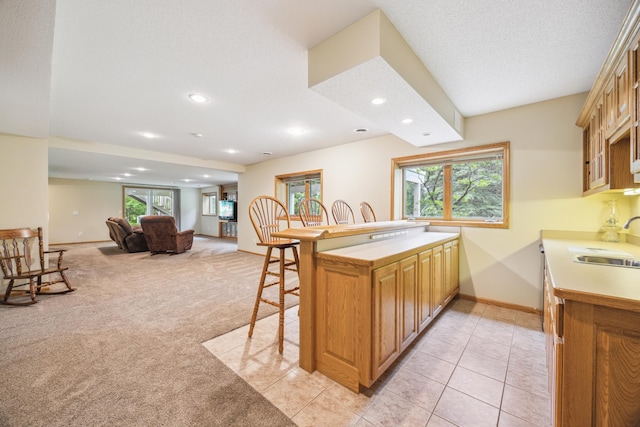 582 139th Ln NW, Andover, MN 55304 - kitchen with a kitchen breakfast bar, a sink, recessed lighting, light carpet, and healthy amount of natural light