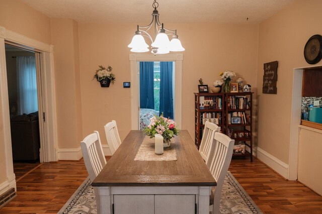 835 Park St, Fairmont, MN 56031 - dining space with a chandelier, dark wood-style flooring, and baseboards