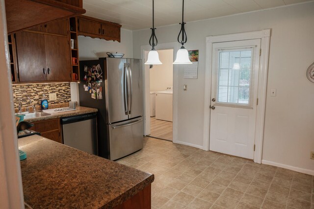 835 Park St, Fairmont, MN 56031 - kitchen featuring appliances with stainless steel finishes, tasteful backsplash, washing machine and clothes dryer, dark countertops, and baseboards