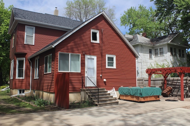 835 Park St, Fairmont, MN 56031 - back of house with entry steps, a pergola, a chimney, a patio area, and roof with shingles
