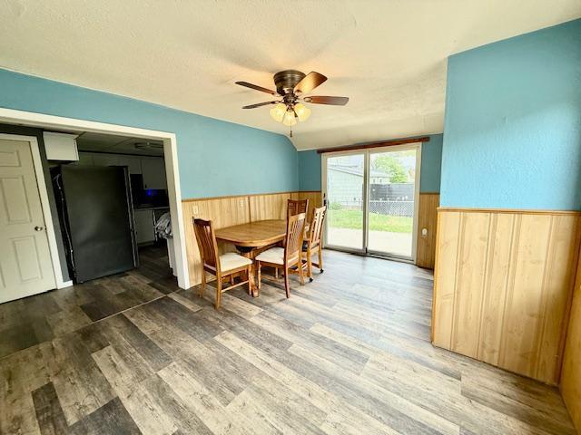 220 Front St E, Redwood Falls, MN 56283 - dining room featuring wainscoting, wooden walls, wood finished floors, and a ceiling fan