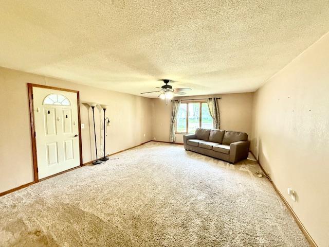 220 Front St E, Redwood Falls, MN 56283 - unfurnished living room featuring carpet, a ceiling fan, a textured ceiling, and baseboards