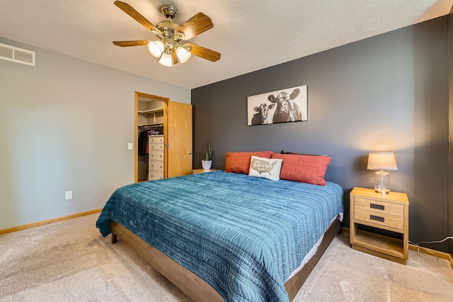 220 Maverick Ave, Elko New Market, MN 55054 - carpeted bedroom featuring a walk in closet, a textured ceiling, a ceiling fan, and a closet