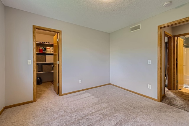 220 Maverick Ave, Elko New Market, MN 55054 - unfurnished bedroom with a walk in closet, carpet floors, a textured ceiling, and a closet