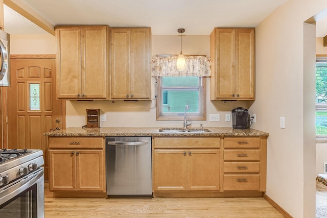 1221 43rd Ave NE, Columbia Heights, MN 55421 - kitchen featuring stainless steel appliances, a sink, light wood-type flooring, and light stone counters
