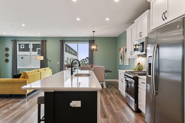 6678 Wildflower Way, Minnetrista, MN 55331 - kitchen featuring stainless steel appliances, a kitchen island with sink, recessed lighting, white cabinetry, and a kitchen bar