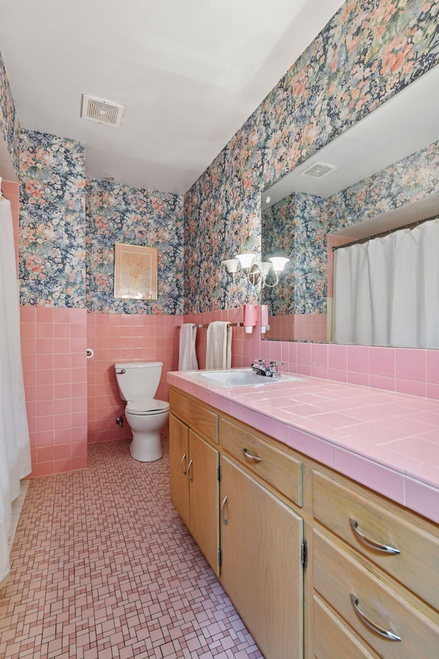5456 Twin Lake Blvd E, Brooklyn Center, MN 55429 - full bath with wallpapered walls, vanity, wainscoting, tile walls, and a shower with curtain