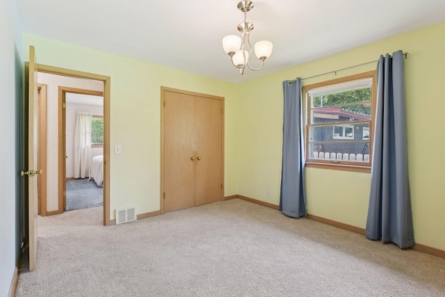 5456 Twin Lake Blvd E, Brooklyn Center, MN 55429 - unfurnished bedroom featuring carpet, a closet, and a chandelier