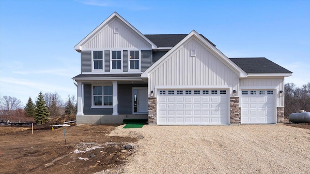 1969 Lusitano St, Shakopee, MN 55379 - view of front of property with board and batten siding, dirt driveway, stone siding, and roof with shingles