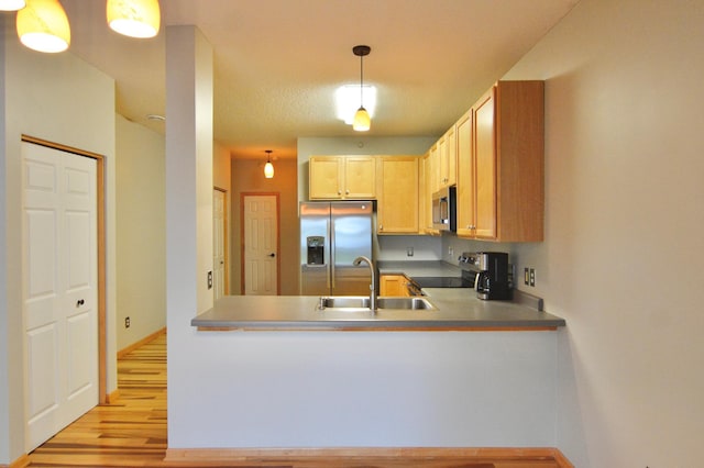 9452 Marshall Rd, Eden Prairie, MN 55347 - kitchen with appliances with stainless steel finishes, a sink, light wood-style floors, a peninsula, and baseboards