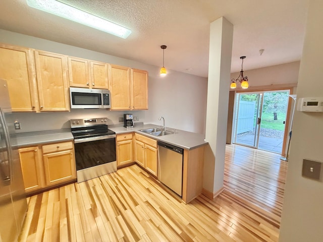 9452 Marshall Rd, Eden Prairie, MN 55347 - kitchen with stainless steel appliances, light brown cabinetry, a sink, light wood-style floors, and pendant lighting