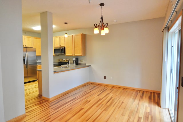 9452 Marshall Rd, Eden Prairie, MN 55347 - kitchen with stainless steel appliances, light brown cabinetry, light wood-type flooring, a peninsula, and baseboards