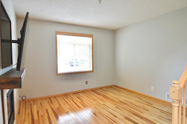 9452 Marshall Rd, Eden Prairie, MN 55347 - unfurnished room with wood-type flooring, baseboards, and a textured ceiling