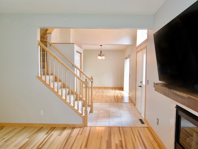 9452 Marshall Rd, Eden Prairie, MN 55347 - foyer entrance featuring wood finished floors, stairway, a chandelier, a tile fireplace, and baseboards