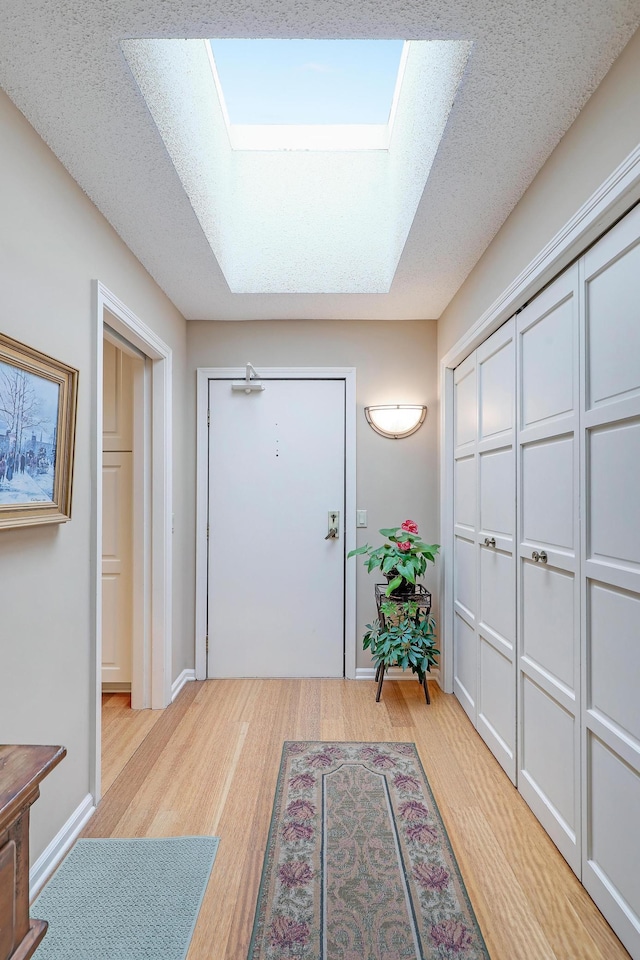 5601 Dewey Hill Rd Unit 310, Edina, MN 55439 - foyer entrance featuring a skylight, light wood finished floors, and baseboards