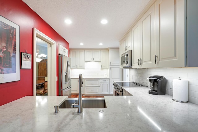 5601 Dewey Hill Rd Unit 310, Edina, MN 55439 - kitchen featuring stainless steel appliances, a sink, backsplash, recessed lighting, and light stone counters