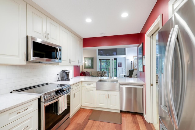 5601 Dewey Hill Rd Unit 310, Edina, MN 55439 - kitchen with appliances with stainless steel finishes, light wood-style flooring, tasteful backsplash, white cabinets, and recessed lighting