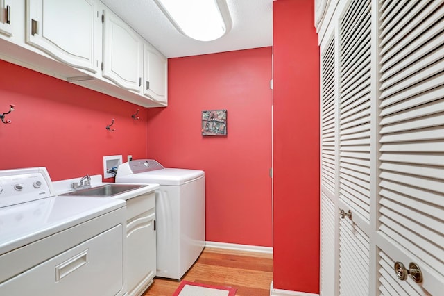 5601 Dewey Hill Rd Unit 310, Edina, MN 55439 - laundry room with cabinet space, independent washer and dryer, light wood-type flooring, and baseboards