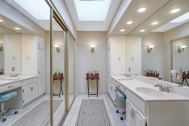 5601 Dewey Hill Rd Unit 310, Edina, MN 55439 - bathroom with a skylight, recessed lighting, double vanity, and baseboards