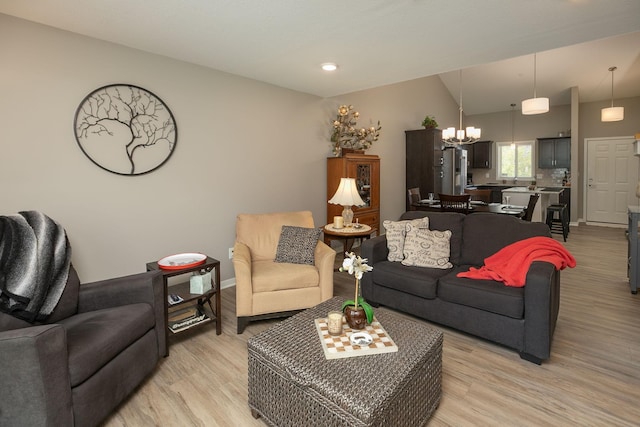 1217 Sundance Ct NE, Byron, MN 55920 - living room with a chandelier, light wood-style flooring, vaulted ceiling, and baseboards