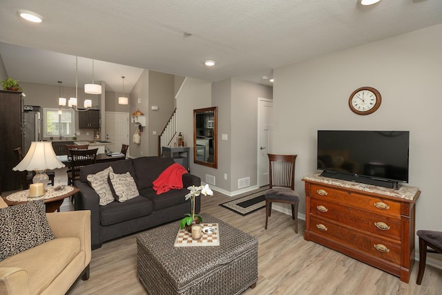 1217 Sundance Ct NE, Byron, MN 55920 - living room featuring stairway, light wood-type flooring, a chandelier, and baseboards