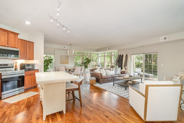 4132 Vernon Ave S Unit A101, Saint Louis Park, MN 55416 - kitchen with appliances with stainless steel finishes, a center island, a breakfast bar area, and light wood-type flooring