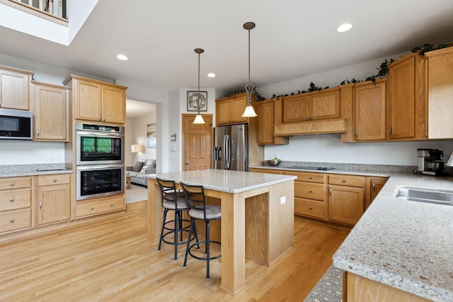 13910 47th Ln NE, Saint Michael, MN 55376 - kitchen featuring appliances with stainless steel finishes, light wood-style floors, a kitchen island, a breakfast bar area, and recessed lighting