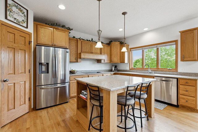 13910 47th Ln NE, Saint Michael, MN 55376 - kitchen with appliances with stainless steel finishes, a kitchen island, light wood-type flooring, recessed lighting, and decorative light fixtures