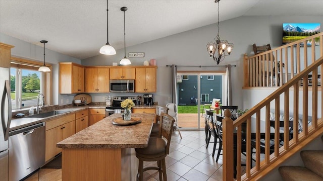 24405 18th Ave, Saint Augusta, MN 56301 - kitchen with stainless steel appliances, a sink, light tile patterned flooring, a kitchen island, and decorative light fixtures