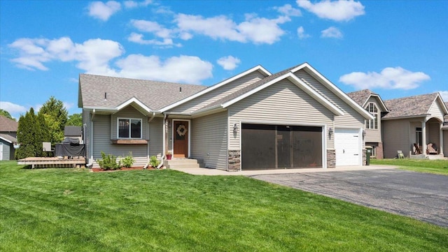 24405 18th Ave, Saint Augusta, MN 56301 - view of front of house featuring asphalt driveway, a garage, a front lawn, stone siding, and roof with shingles