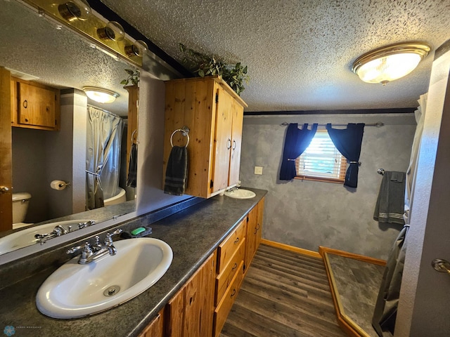 4732 San Juan Dr, Fargo, ND 58103 - bathroom featuring toilet, a textured ceiling, wood finished floors, vanity, and baseboards