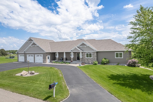 2142 Monarch Ct, Sartell, MN 56377 - view of front facade with covered porch, stone siding, a front lawn, a garage, and asphalt driveway