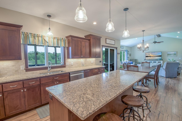 2142 Monarch Ct, Sartell, MN 56377 - kitchen featuring a sink, light wood finished floors, light stone counters, open floor plan, and vaulted ceiling