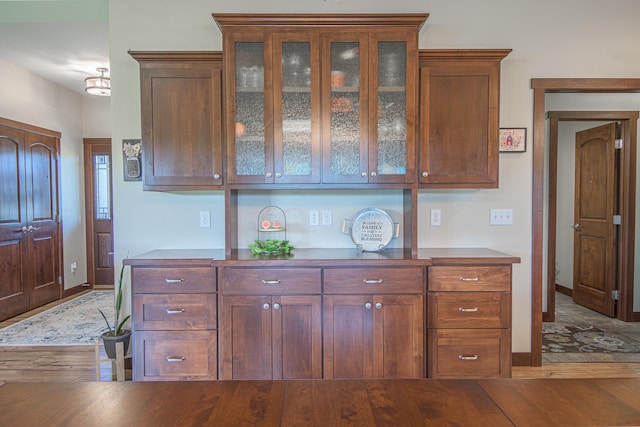 2142 Monarch Ct, Sartell, MN 56377 - kitchen with wood finished floors, baseboards, and glass insert cabinets