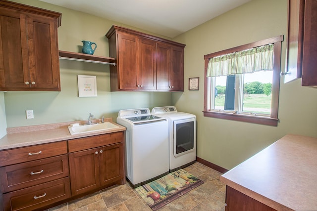 2142 Monarch Ct, Sartell, MN 56377 - laundry area featuring washing machine and dryer, cabinet space, light stone finish flooring, and baseboards