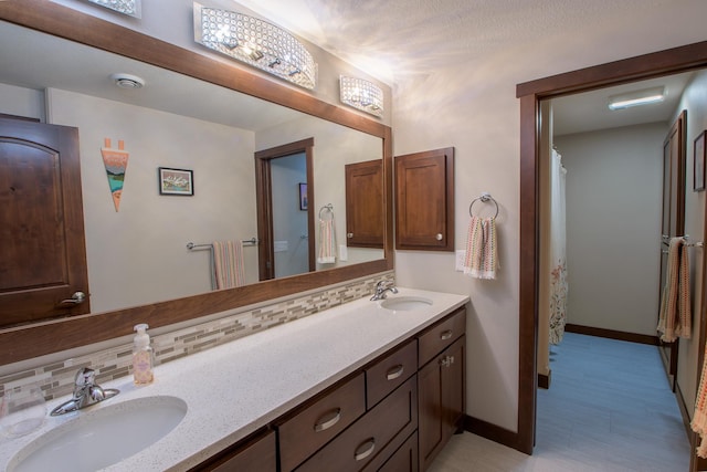2142 Monarch Ct, Sartell, MN 56377 - full bathroom featuring double vanity, baseboards, and decorative backsplash